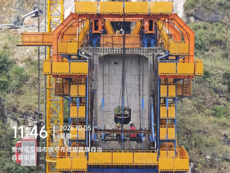 Front site view with multiple yellow platform levels around a concrete box-girder segment