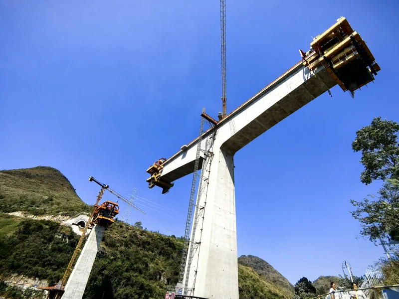 Supplied site photograph of a high-pier bridge with cantilever construction equipment at the deck ends